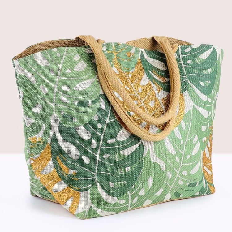 Jute shopper bag with muted green and gold mix monstera leaf print, finished with cotton handles