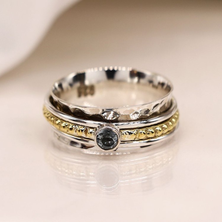 Sterling silver spinning ring with blue topaz on a brass band